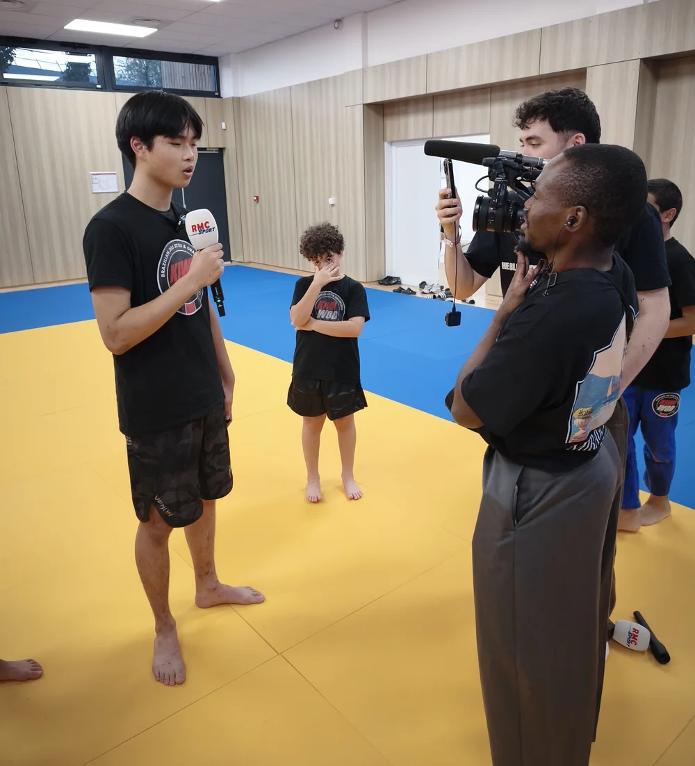 Un jeune du club Kiwi Wod répond au micro de RMC Sport, face au journaliste et au cadreur