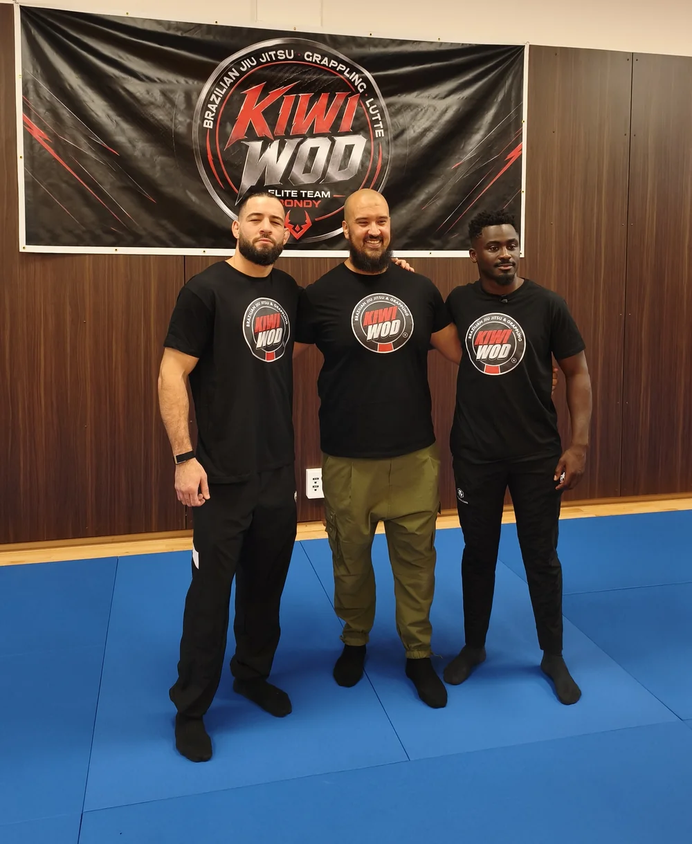 Mohamed Lamraoui, fondateur de Kiwi Wod, entouré des combattants de l'UFC Nassourdine Imavov et William Gomis, sous la banderole du club