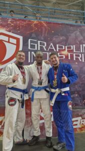 trois athlètes KiwiWOD présentant leurs médailles après leurs victoires en Jiu-Jitsu